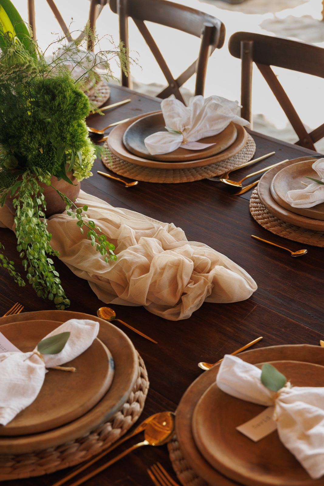 Elegant place setting with gold cutlery and flowing table runner