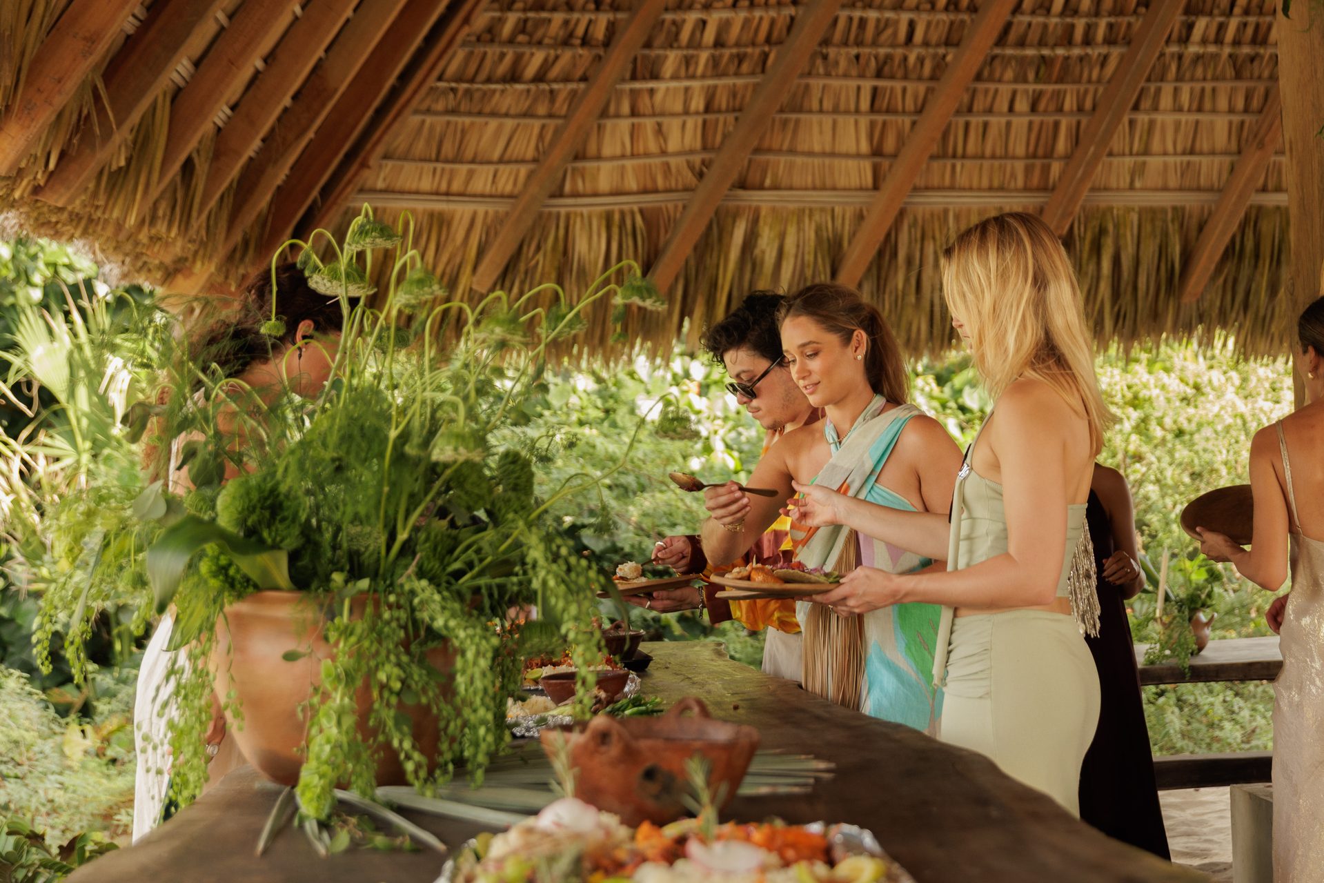 Wedding guests enjoying buffet under tropical palapa in Puerto Escondido