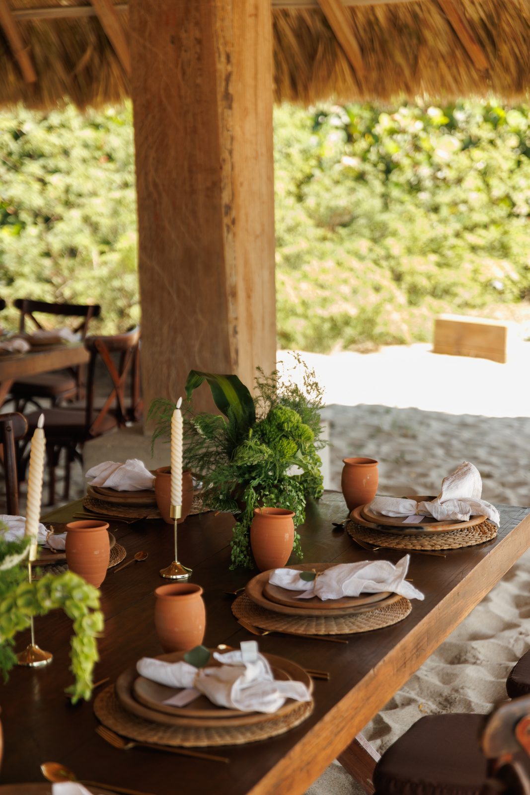 Elegant table set under thatched palapa with ocean view