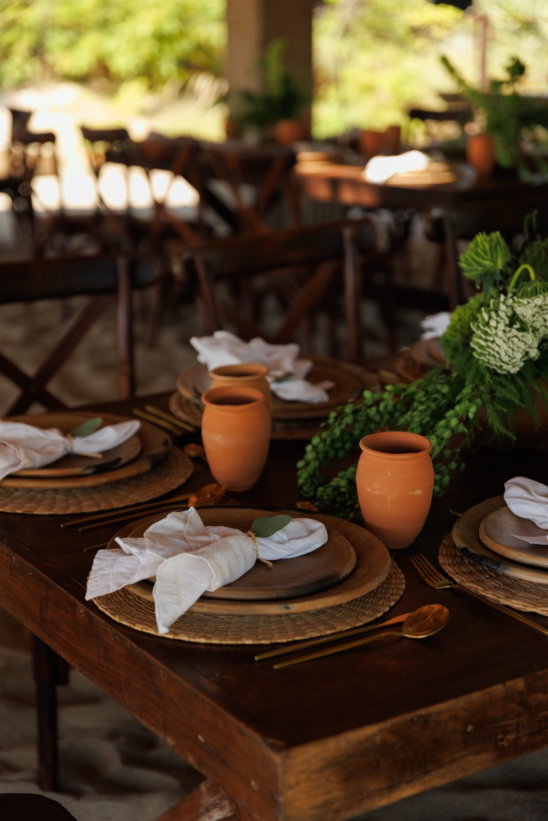 Rustic place setting with woven charger and greenery