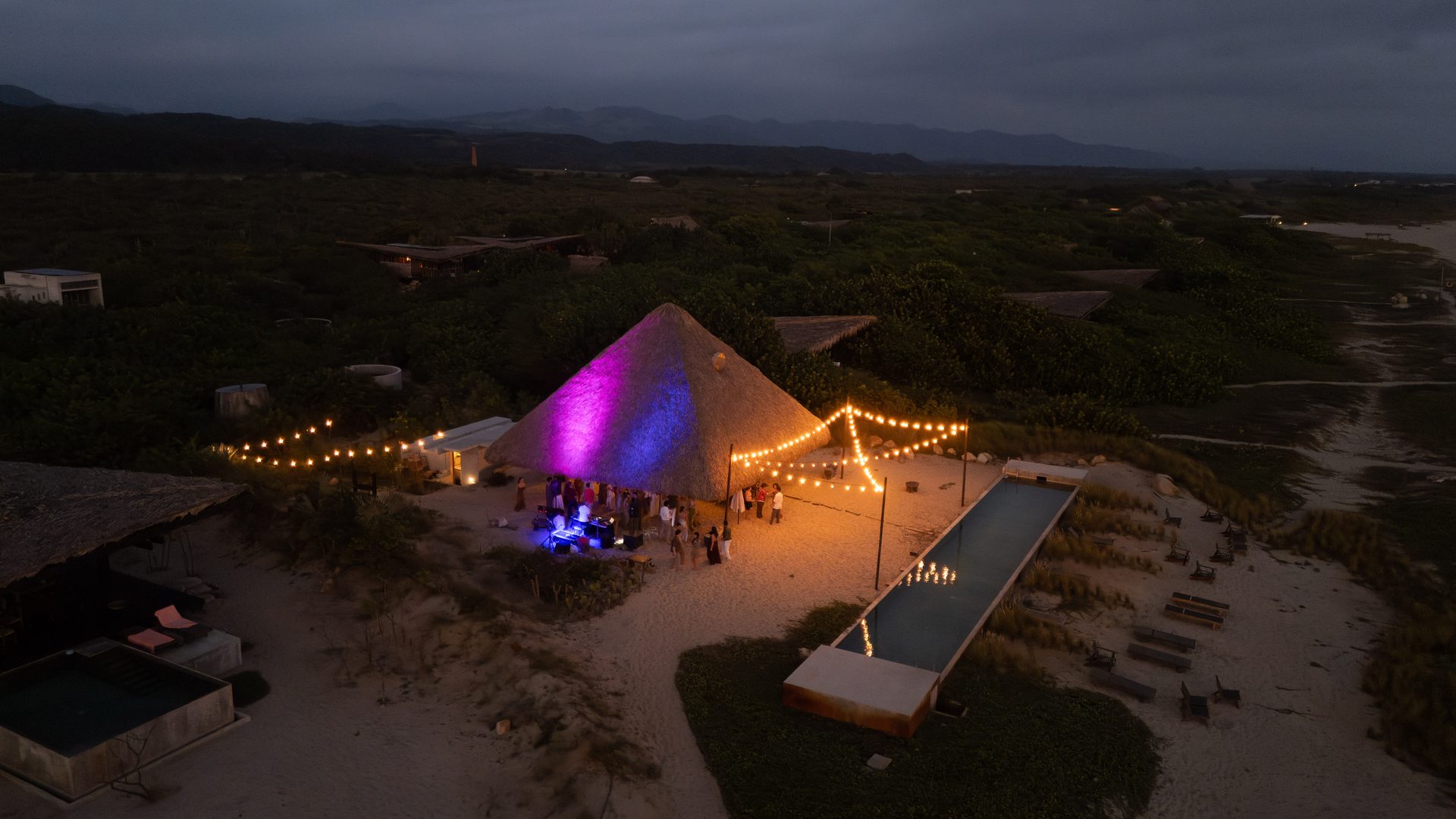 Aerial view of wedding venue at night with string lights and palapa in Puerto Escondido